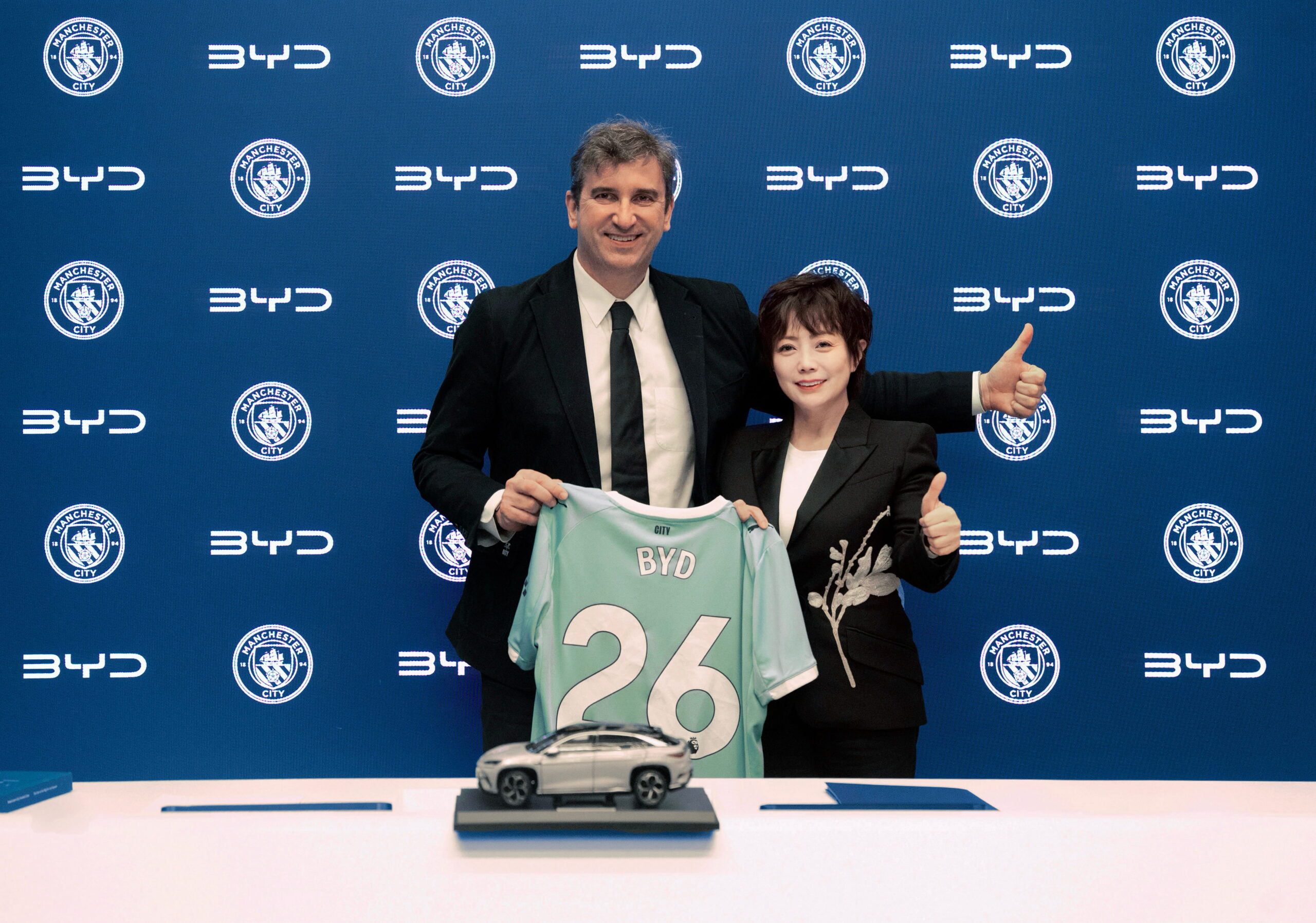 Annonce du partenariat BYD Manchester City avec dirigeants posant devant le logo du club et maillot officiel