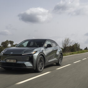 Toyota C-HR+ SUV électrique en conduite sur route avec design coupé et signature lumineuse avant