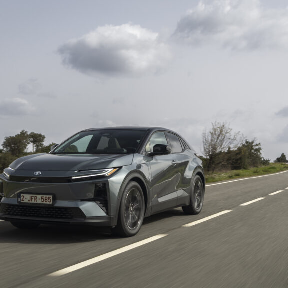 Toyota C-HR+ SUV électrique en conduite sur route avec design coupé et signature lumineuse avant