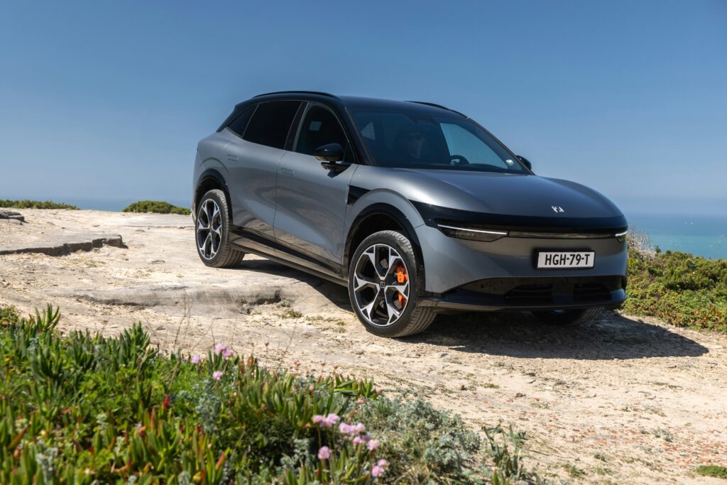 SUV électrique Geely en finition grise stationné en bord de mer sur route côtière