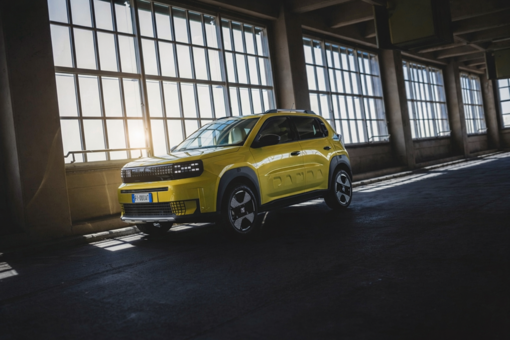 Fiat Panda électrique jaune dans un hangar industriel avec lumière naturelle et ambiance urbaine