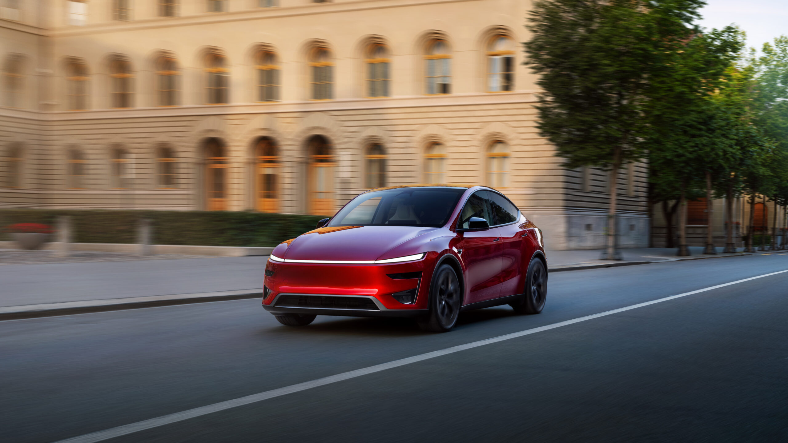 Tesla Model Y Performance rouge roulant en milieu urbain avec design restylé