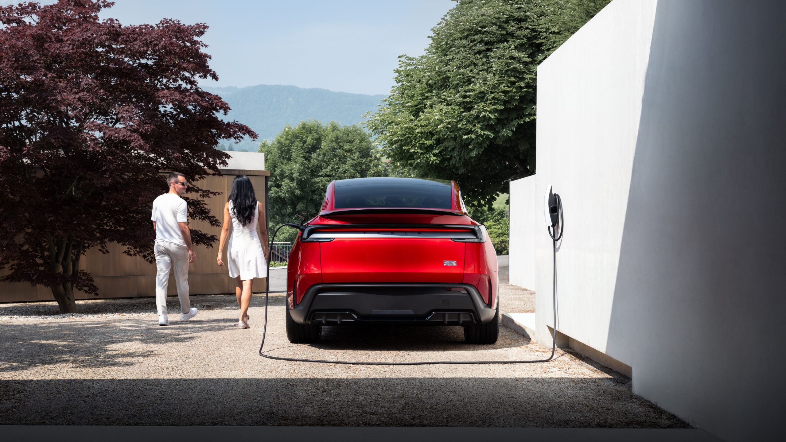 Tesla Model Y Performance rouge branché sur borne de recharge résidentielle