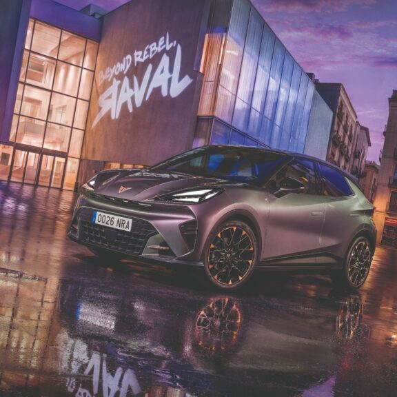 Cupra Raval électrique au design sportif dans une rue urbaine sous la pluie