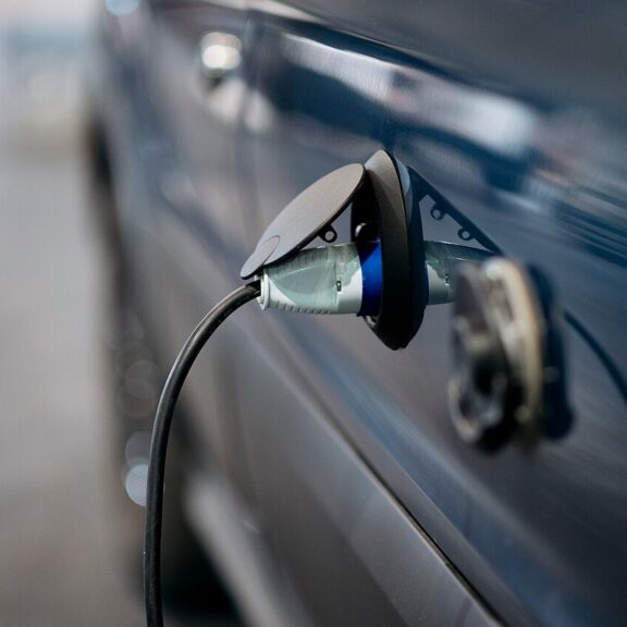 Voiture électrique bleue branchée à une borne de recharge