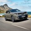 BMW iX5 60 xDrive vue de trois-quarts avant sur une route côtière