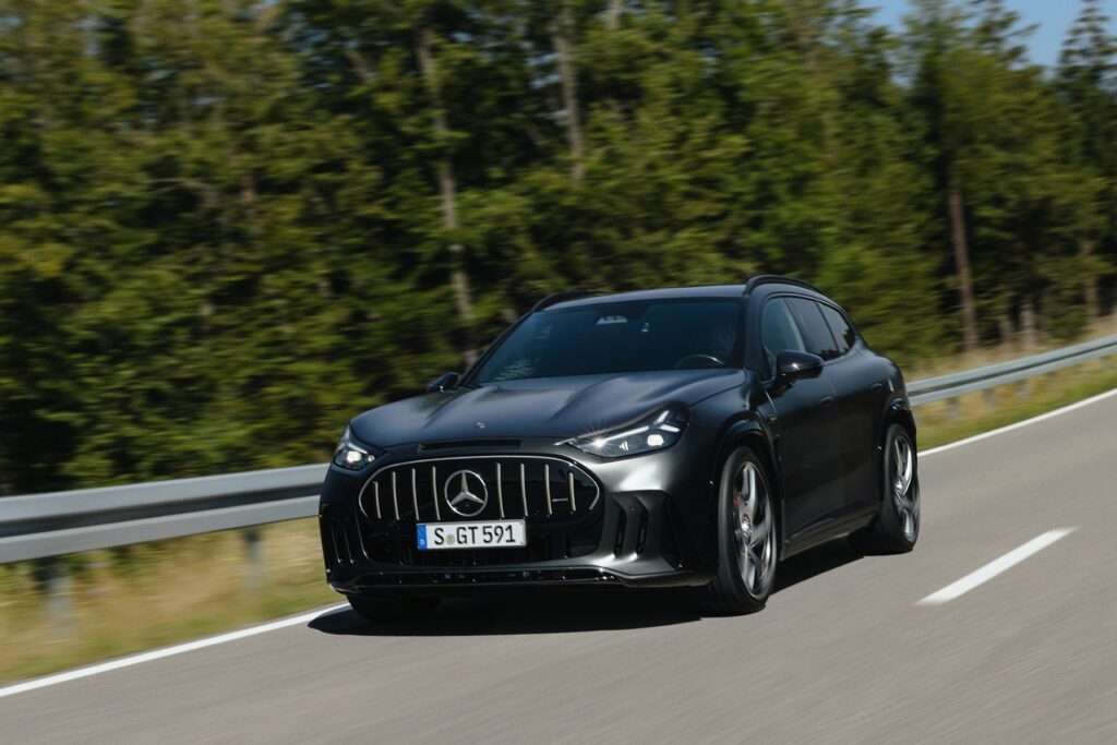 Le GT SUV de teinte noire en roulage, vu de trois quarts avant devant une forêt (photo officielle Mercedes-AMG)