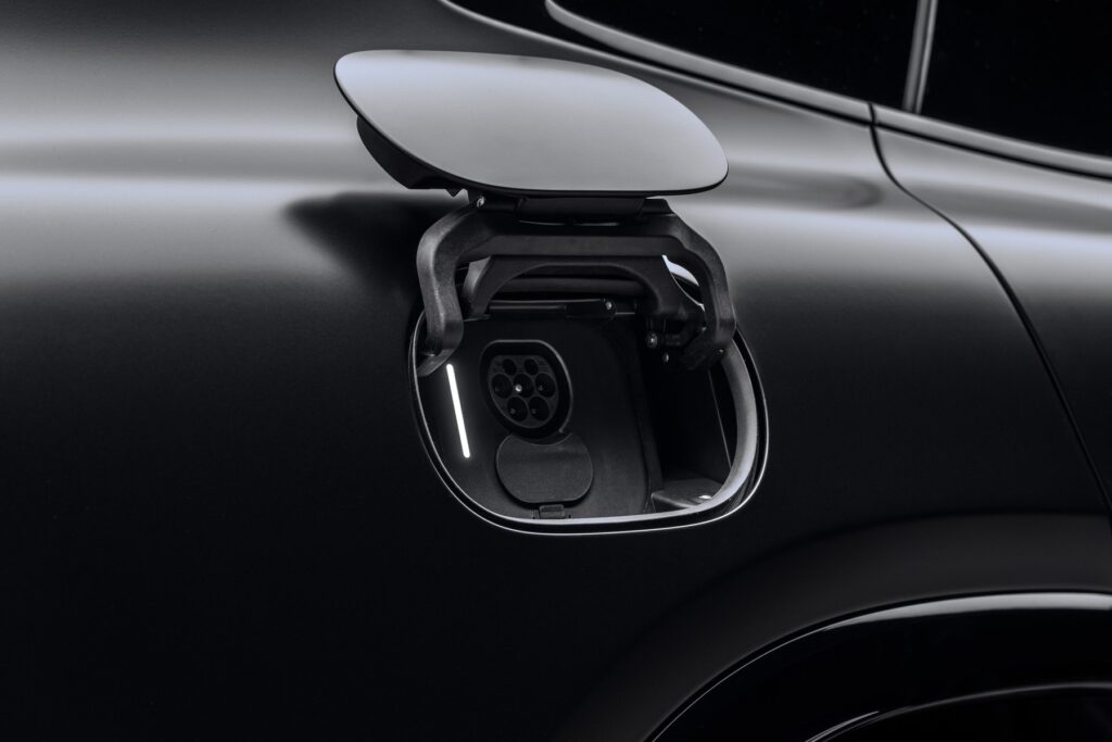 Trappe de recharge ouverte, avec sa prise, sur une carrosserie noire (photo constructeur)
