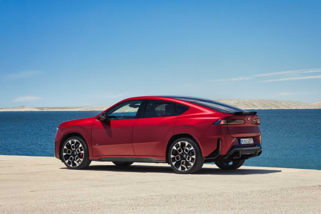 SUV coupé électrique rouge vu de trois quarts arrière au bord de la mer (photo constructeur)