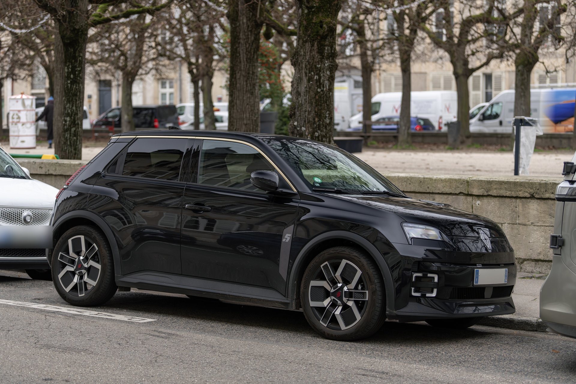 Renault 5 E-Tech électrique noire garée en ville, vue de trois quarts avant