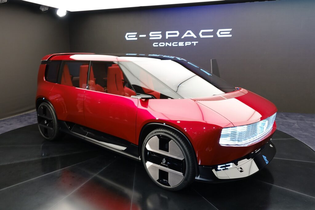 Renault E-Space Concept rouge de trois quarts avant sur son stand du Mondial de l’Auto 2026, sièges rouges visibles par les vitres