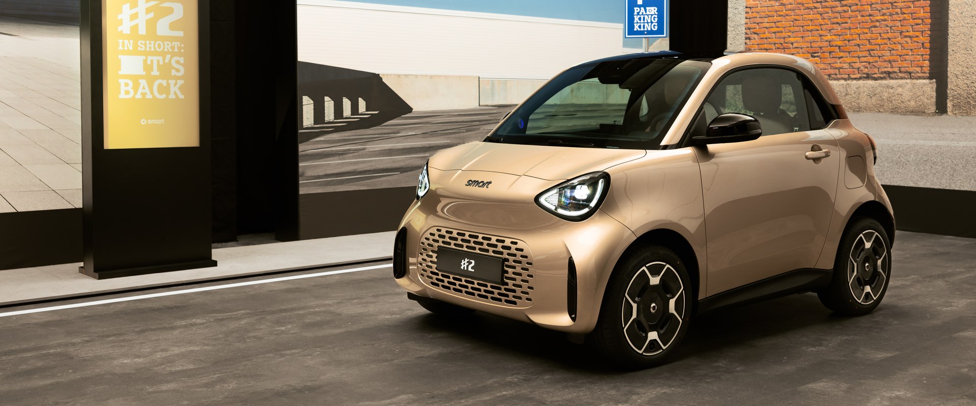 smart #2 de teinte champagne vue de trois quarts avant, devant un panneau « #2 » (image officielle smart)