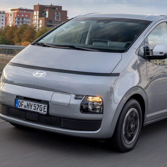 Hyundai STARIA Cargo gris en roulage sur un pont, devant les immeubles d’une ville (photo officielle Hyundai)
