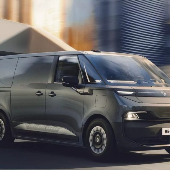 Utilitaire électrique gris foncé en roulage dans une rue de ville, vu de trois quarts avant (visuel officiel Renault)